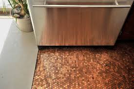Painstakingly gluing their change jar's contents to the 324 square foot floor and sealing it with a clear coat took a total 128 hours, and many dirty hands. Penny Floor