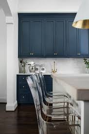 Royal Blue Kitchen Cabinets Adorned With Brass Hardware Are Mounted Above White Subway Back Blue Kitchen Tiles Blue Kitchen Cabinets Dark Blue Kitchen Cabinets