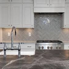 White Raised Panel Kitchen Cabinets With Gray Geometric Tile Backsplash Transitional Kit Trendy Kitchen Backsplash Kitchen Tiles Backsplash Kitchen Remodel