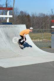 Portrait of a young skateboarder skating on a ramp at the skate park.  Royalty-Free Stock Image - Storyblocks