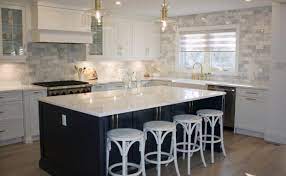 Stunning kitchen features dark brown stained cabinets adorned with brass cup pulls topped with grey and white marble countertops fitted with a stainless steel sink and gooseneck faucet placed under dark brown stacked floating shelves illuminates by antique brass sconces. 21 Quartz Kitchen Islands Ideas To Inspire Your Dream Kitchen Hanstone Quartz