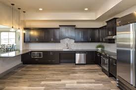 The deep brown cabinets warm this rustic kitchen. Dark Cabinets Light Floor Kitchen Cabinets And Flooring Dark Cabinets Light Floor Brown Kitchen Cabinets