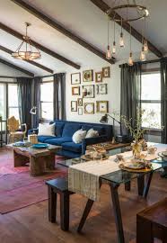 Wooden table in front of beige settee with pink pillows in flat interior with posters and plant. 75 Beautiful Eclectic Living Room Pictures Ideas January 2021 Houzz