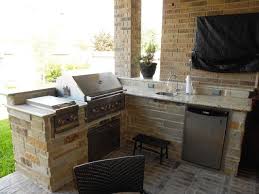 An outdoor kitchen features a pizza oven, grill, sink and more. Outdoor Kitchens Houston Katy Dallas Cinco Ranch Texas Custom Patios Outdoor Kitchen Design Patio Kitchen Outdoor Kitchen