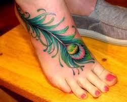 Sugar skull on foot and a tribute to mom and dad. Pin By Christina Huber On Ink Piercings Peacock Feather Tattoo Feather Tattoos Feather Tattoo Foot