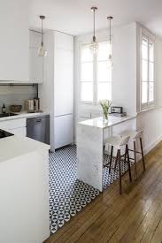 A clean white countertop and glossy brown cabinetry, paired with simple brown backed barstools give a modern feel to this kitchen. 7 Polished Kitchen Peninsula Ideas To Consider Over A Standard Island In 2020 Small Apartment Kitchen Kitchen Design Small Kitchen Remodel Small