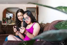 Mexican Girl With Down Syndrome And Her Mother Spending Time Together Using  The Phone At Home, In Disability Concept In Latin America Stock Photo,  Picture and Royalty Free Image. Image 172737840.