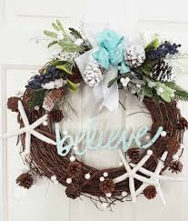 The garland is adorned with shimmery aqua ombre ribbon, starfish, pinecones, and beautiful rope wrapped blue glass ornaments. Coastal Christmas Wreath Sand Dollar Lane