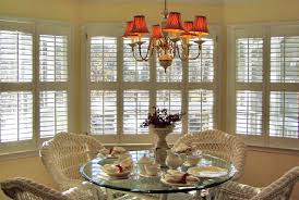 Chic living room boasts a lucite table abr lined with libations flanked by windows dressed in plantation shutters. Plantation Shutters Versatile Window Treatment Between Naps On The Porch