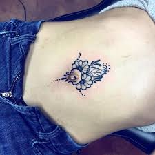 A simple scrolled design is rendered in black ink underneath the wearer's belly button in this tattoo. 20 Beautiful Stomach Tattoos For Females Entertainmentmesh