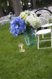 Shepherds Hooks With Blue Mason Jars Filled With Hydrangeas Lined The Aisle Wedding Flowers Blue Mason Jars Table Centerpieces