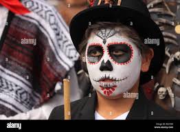 Jeune garçon avec beau crâne en sucre (Catrina) un miroir à jour de  célébration des morts Photo Stock