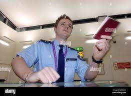 A Immigration Officer Checks A Passport From A Passenger Arriving At  Terminal 1 At Heathrow Airport Stock Photo - Alamy