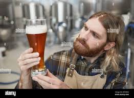 Portrait of man brewmaster with glass of beer Stock Photo