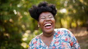 Portrait of happy african women laughing with yellow turban, jacaranda tree on the background, amazing face. Why Laughter Is So Good For You And How To Do It More Everyday Health