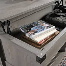 It is finished on all sides, it has a top that lifts up and forward, hidden storage beneath the top, open shelves for additional storage and display and an elegant washington cherry finish. Sauder Carson Forge Lift Top Wood And Metal Coffee Table In Mystic Oak 426149