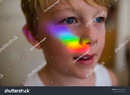 Joven con un arco iris en Foto de stock 1954520083