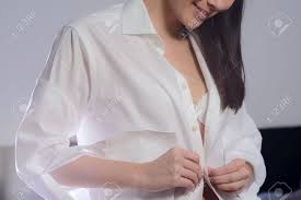 Young Woman Unbuttoning Her White Shirt As She Prepares To Go ...