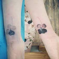 Many watercolor tattoo critics argue that these types of tattoos will not look good for very long and will fade quickly since they are made up of very soft colors, which lack much contrast. Watercolor Style Flower Cover Up Tattoo On The Right