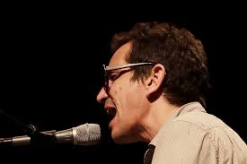 A.J. Croce op zijn praatstoel achter de vleugel