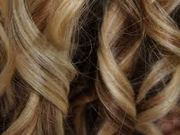 Donna bruna con i capelli ricci lunghi e lucenti. Come Fare I Boccoli Con La Piastra Dritte E Consigli Per Un Risultato Perfetto