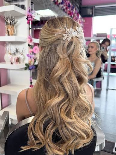 Bridal Waves 🕊️ This bridal hairstyle features soft, voluminous waves blended with a half-up twist for the perfect romantic finish. The look is completed with a delicate pearl and floral hairpiece, adding