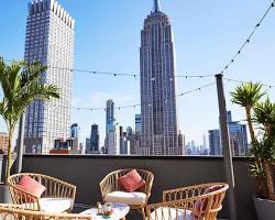 Image of person looking at the view from a rooftop bar in New York City