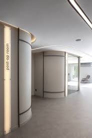 a lekerekitett faliv es a mennyezet kozepen vegigfuto led feny ami vezeti az embert es megfelelo megvil in 2021 clinic interior design healthcare design clinic design