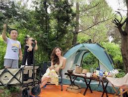 Vợ chồng trẻ chăm cho con đi cắm trại để tận hưởng cuộc sống