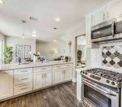 A peninsula with waterfall countertop helps separate the kitchen from the adjacent room. Flip Or Flop Kitchen Cabinet Brand Etexlasto Kitchen Ideas