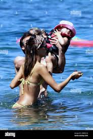 Wearing a tiny yellow bikini, Victorias Secret Angel Alessandra Ambrosio,  husband Jamie Mazur and their daughter Anja Louise spend a day at the  beach. The group posed for photos and went for