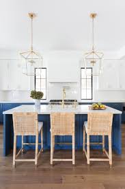 White and gold kitchen features white shaker cabinets adorned with brass hardware paired with calcutta marble countertops and a white subway tile backsplash facing a wall of floor to ceiling gray cabinets painted benjamin moore cape may cobblestone. Bright Blue And White Chef S Kitchen With Gold Accents Hgtv S 2019 Designer Of The Year Awards Hgtv