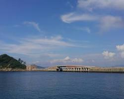 高島飛島磯釣公園で釣りを楽しむ人たち、背後に長崎市街地が見えるの画像