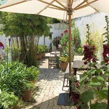 chaud au soleil et bien a l abri sous un parasol quel plaisir de deguster un cafe avec son verre d eau au milieu des fl patio patio umbrella outdoor decor