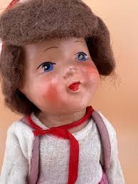 Vintage Puppe mit rosa Rock und roten Schleifen