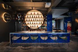 Black bamboo rolls used as wall covering on a patio. O O Studio Completes Mooncraft Bar With Dark Interior In Shanghai