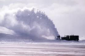 A truck equipped with a snow blower clears one of the base's runways