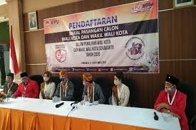 Petugas kpps mengenakan pakaian hazmat dan alat perlindungan diri (apd) di tempat pemungutan suara (tps) 039 pada pilkada kota solo 2020 di dukuhan, nayu, banjarsari, solo, jawa tengah, rabu (9/12/2020). Bapaslon Gibran Teguh Resmi Jadi Peserta Pilkada Politik