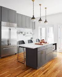 Charcoal Gray Kitchen Boasts Three Small Hicks Pendants Hung Over A Gray Island Fitted With Gray Cabinets And Draw Grey Kitchens Kitchen Flooring Grey Cabinets