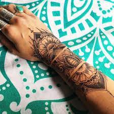 Black henna flower band tattoo on wrist. Pin By Louise Thiessen On Tattoos Henna Inspired Tattoos Hand Tattoos Tattoos
