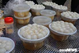 Ấn dẹt viên bột, đặt viên đậu xanh vào giữa, miết bột phủ khi nước đường bắt đầu sôi thì vớt bánh từ bát vào nồi, đun sôi trở lại rồi tắt bếp. áº£nh NgÆ°á»i Ha Ná»™i Xáº¿p Hang Mua Banh Troi Banh Chay Ngay Táº¿t Han Thá»±c
