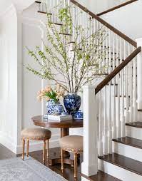 The dark woods and red accents balance against the light wall color and provide warmth and depth. Portfolio August Taylor Design Home Decor Foyer Design Chic Dining Room