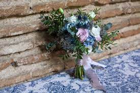 The dark blue color of the berries next to the light orange, pastel pink and white garden roses come together to create a bouquet that captures winter and compliments the bride's beauty. Wedding Bouquet Of Bride Bridal Flowers Bouquet In Wedding Day With Blue White Pink And Green Flowers Over Brick Wall Stock Photo Picture And Royalty Free Image Image 36140780