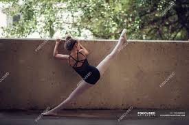 Two young girls posing on the beach. Back View Of Beautiful Little Girl Ballerina Holding Wall And Stretching Caucasian Adorable Stock Photo 193458282