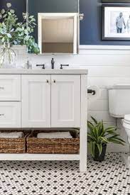 Cottage bathroom with a pocket door is designed with a faded vintage runner atop light oak plank floors between a white vanity and a freestanding tub next to a walk in shower. 5 Things Your Modern Cottage Bathroom Needs A Pop Of Pretty Home Decor Ideas Black And White Bathroom Floor Cottage Bathroom Modern Cottage Bathroom