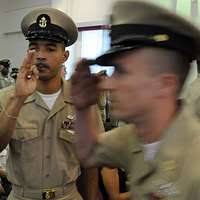 Senior Chief Aviation Boatswain's Mate (Handling) Jared Mueller, assigned  to the Wasp-class amphibious assault ship USS Essex (LHD 2), hugs his  children before Essex leaves for a deployment.