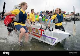Katherine Bell, left, and Olivia Tracy, of South Windsor High School,  plunge into the water with their entry in the high school division of the  Annual University of Connecticut Avery Point Associated