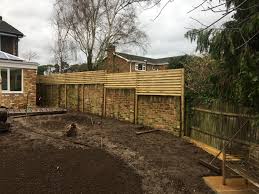 Lush ivy and climbing roses adorn the exterior of this privacy fence, teasing the passersby with a taste of the beauty behind its walls. A Shutter Screen Trellis In Maidenhead Alda Landscapes