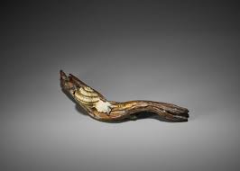 A wood netsuke of a snail inscribed tadatoshi carved as a snail with its feelers extended over it shell, the natural himotoshi formed by the curling foot. Lot 252 Kodo A Superb Inlaid And Lacquered Wood