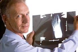 Mature Doctor Reviewing Xray Of Foot Stock Photo